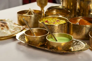 Las dos salsas del Lunch box, una ámbar y otra verde, en cuencos de latón