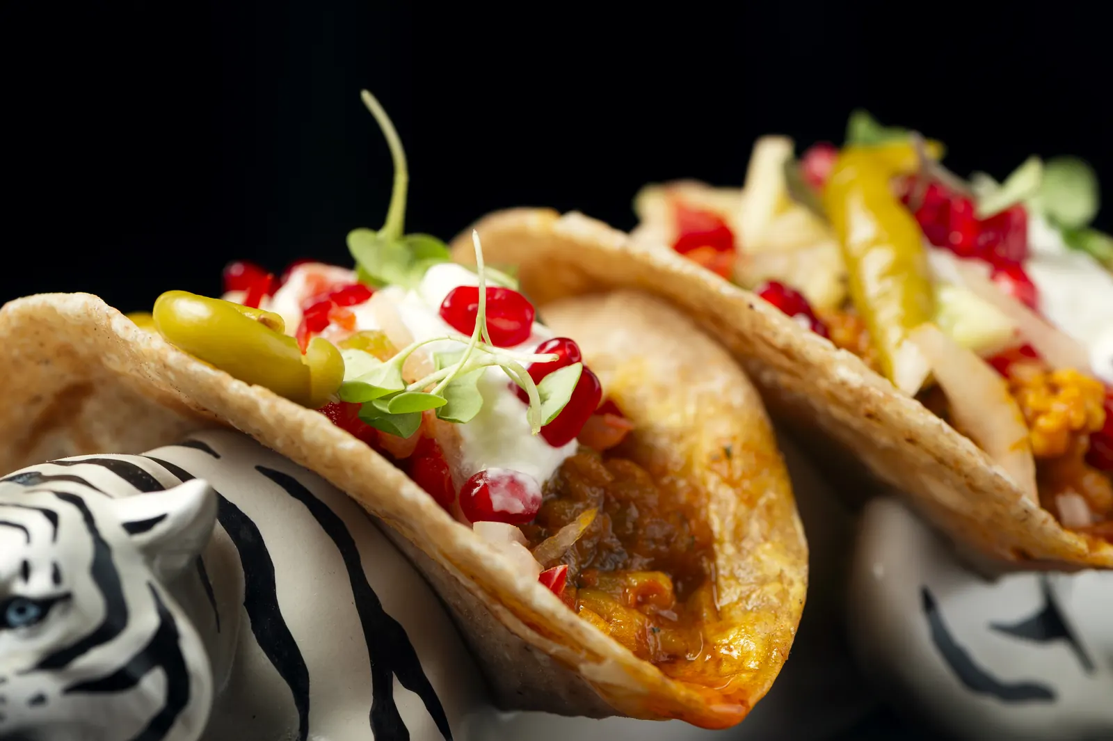 Tiger tacos de cerca: pan paratha con gambas, yogur y granada, servidos sobre la figura de un tigre